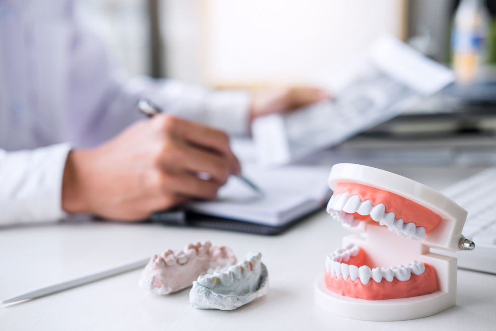 Close up of some full and partial dentures on a dentist's desk during a consultation.