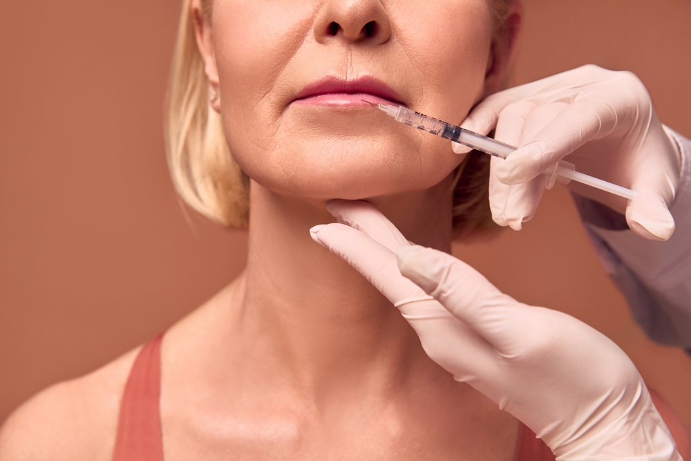 Woman having Botox injection near her mouth after her dental procedure.