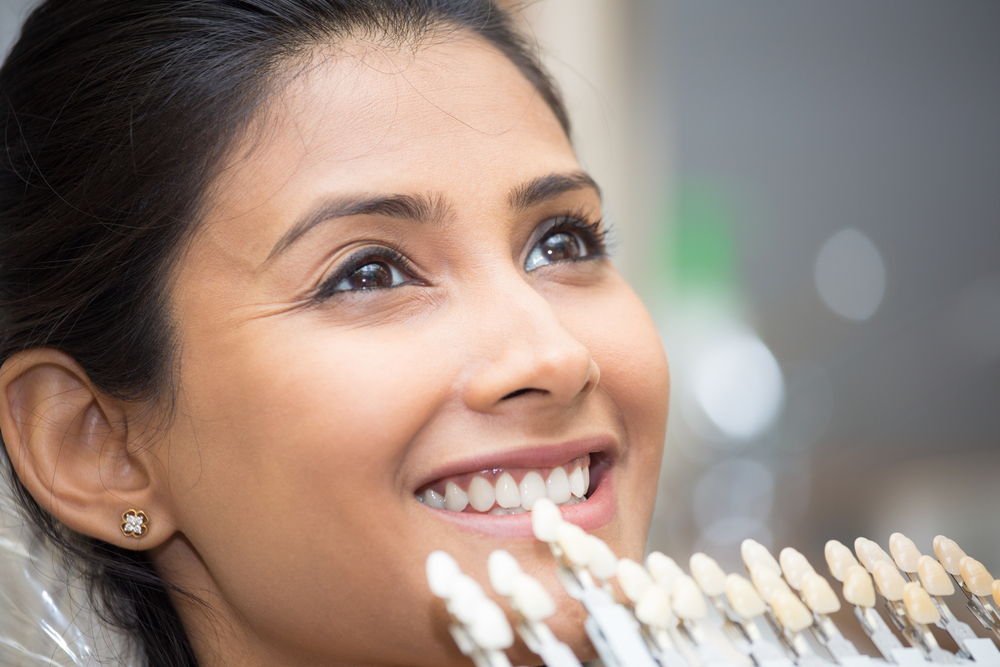 Close up of a woman having her teeth color-matched for porcelain dental restorations.
